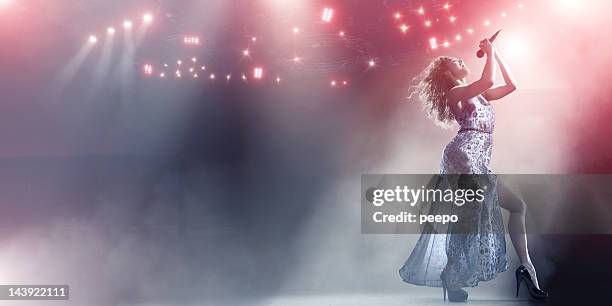 a female singer holds a microphone on a huge stage. - nattklubbssångare bildbanksfoton och bilder