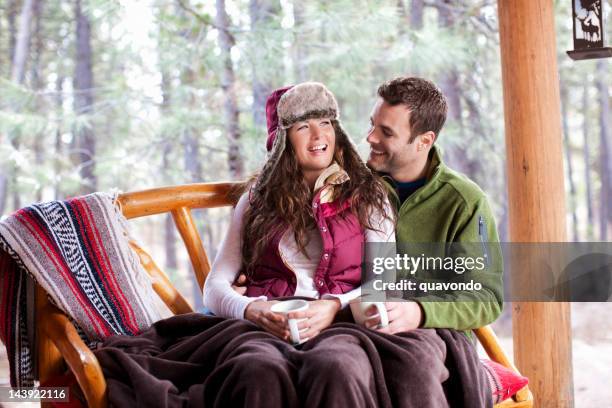 adorable young couple cuddling outdoors at winter cabin - waistcoat stock pictures, royalty-free photos & images