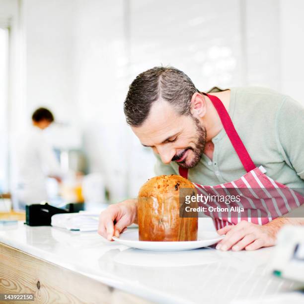 chefkoch riechen panettone - baker smelling bread stock-fotos und bilder