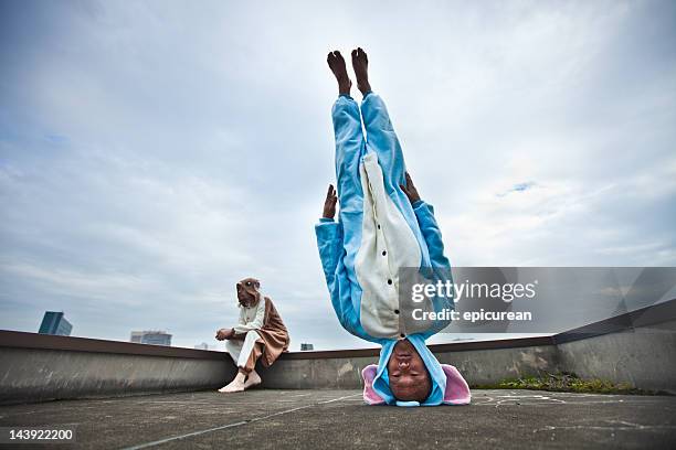 japanese man standing on his head in elephant costume - animal sport stockfoto's en -beelden