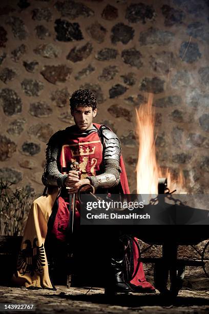 mittelalterliche ritter sitzt in der dunkelheit in brand geschlossen - schwert stock-fotos und bilder