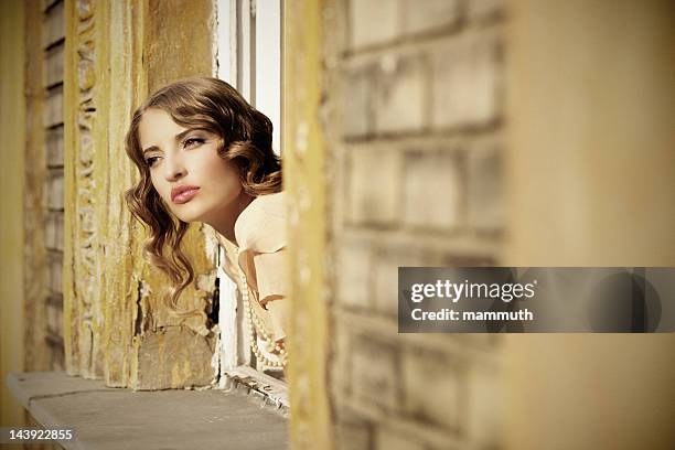 retro girl looking out of the window - 1900s woman stockfoto's en -beelden