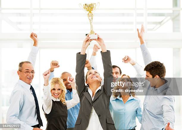 cheerful group of businesspeople winning the cup with hands up. - aansporing stockfoto's en -beelden