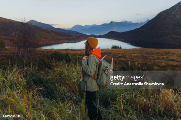 a woman contemplating sunset hiking to the lake in the mountains in norway - more og romsdal bildbanksfoton och bilder