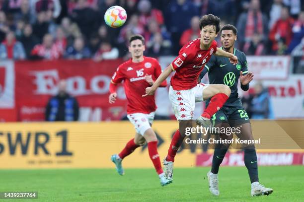Lee Jae-Song of 1.FSV Mainz 05 passes while under pressure from Felix Nmecha of VfL Wolfsburg during the Bundesliga match between 1. FSV Mainz 05 and...