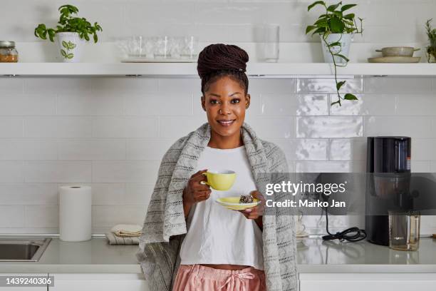 portrait of a beautiful young black woman in the kitchen, drinking morning coffee - immune system stock pictures, royalty-free photos & images