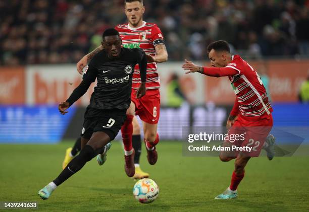 Randal Kolo Muani of Frankfurt is challenged by Iago of Augsburg during the Bundesliga match between FC Augsburg and Eintracht Frankfurt at WWK-Arena...