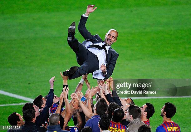 Barcelona players throw Josep Guardiola their head coach into the air at the end of the La Liga match between FC Barcelona and RCD Espanyol at Camp...