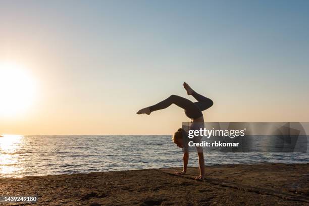 teen girl in a handstand by the sea - handstand beach photos et images de collection