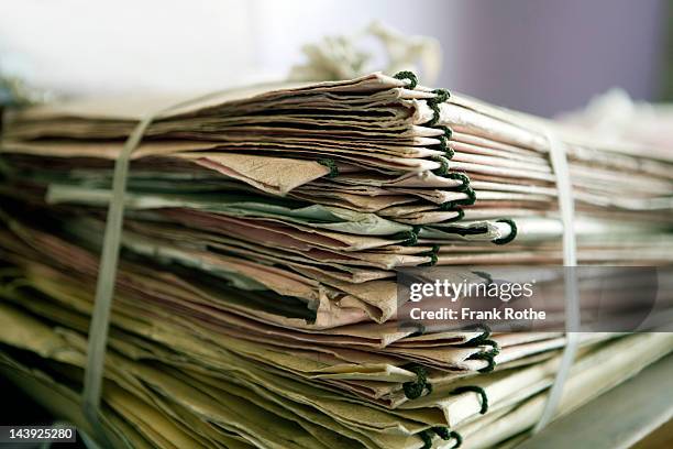a stack of papers on a table - sala de arquivos imagens e fotografias de stock