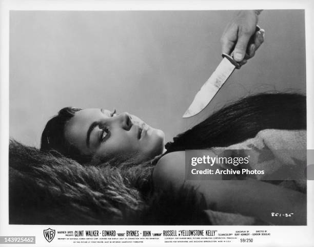 Andra Martin has knife drawn on her in a scene from the film 'Yellowstone Kelly', 1959.