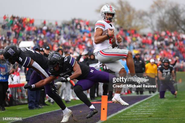 Emeka Egbuka of the Ohio State Buckeyes scores a touchdown past Jeremiah Lewis and Rod Heard II of the Northwestern Wildcats during the first half at...