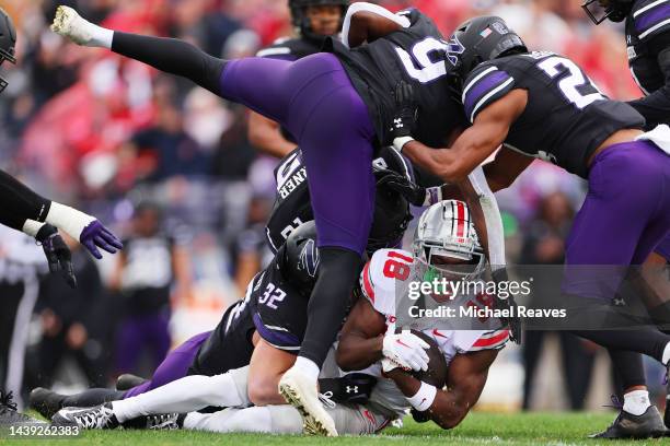 Marvin Harrison Jr. #18 of the Ohio State Buckeyes is tackled after a reception against the Northwestern Wildcats during the first half at Ryan Field...