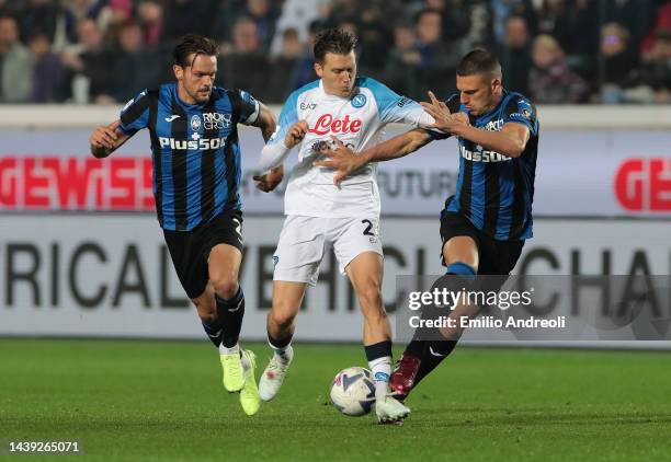 Piotr Zielinski of SSC Napoli is challenged by Merih Demiral and Rafael Toloi of Atalanta BC during the Serie A match between Atalanta BC and SSC...