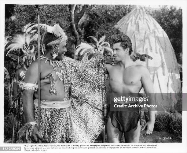 Rex Ingram and Gordon Scott make the sign of friendship in a scene from the film 'Tarzan's Hidden Jungle', 1955.