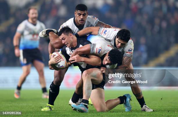 Joseph Manu of New Zealand is tackled by Siua Wong and Lamar Manuel-Liolevave of Fiji during the Rugby League World Cup Quarter Final match between...