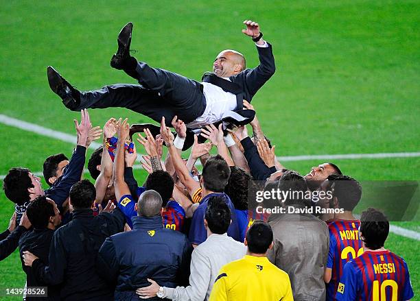 Barcelona players throw Josep Guardiola their head coach into the air at the end of the La Liga match between FC Barcelona and RCD Espanyol at Camp...
