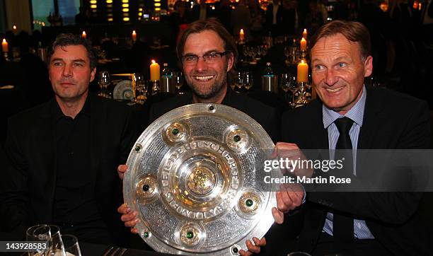 Michael Zorc, manager of Dortmund, Juergen Klopp, head coach of Dortmund and managing director Hans Joachim Watzke pose with the trophy at View...