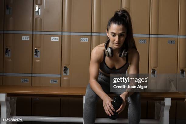 hispanic sportswoman with bottle in dressing room - woman backstage stock pictures, royalty-free photos & images