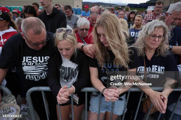 Ronald Rabo, Kendra Rabo, Katie Rabo and Kim Lesko pray during the invocation prior to a rally featuring former U.S. President Donald Trump at the...