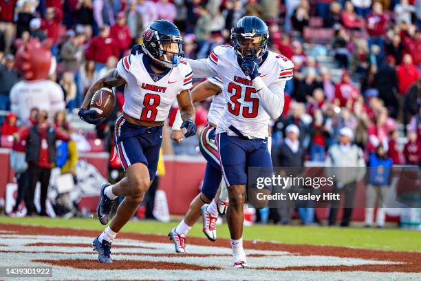 Daijahn Anthony celebrates with Tyren Dupree of the Liberty Flames after in intercepting a pass in the end zone during the first half of a game...