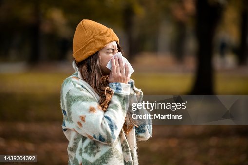 Woman sneezing in handkerchief at autumn Woman sneezing in handkerchief at autumn