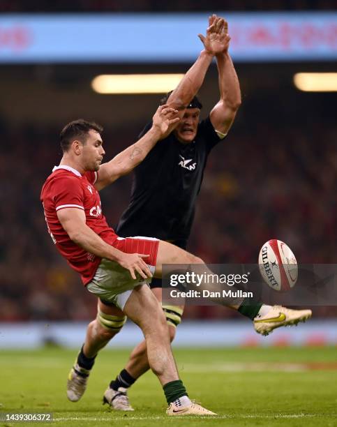 Tomos Williams of Wales kicks under pressure from Scott Barrett of New Zealand during the Autumn International match between Wales and New Zealand...