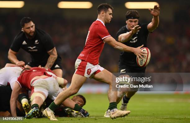 Tomos Williams of Wales kicks under pressure from Scott Barrett of New Zealand during the Autumn International match between Wales and New Zealand...