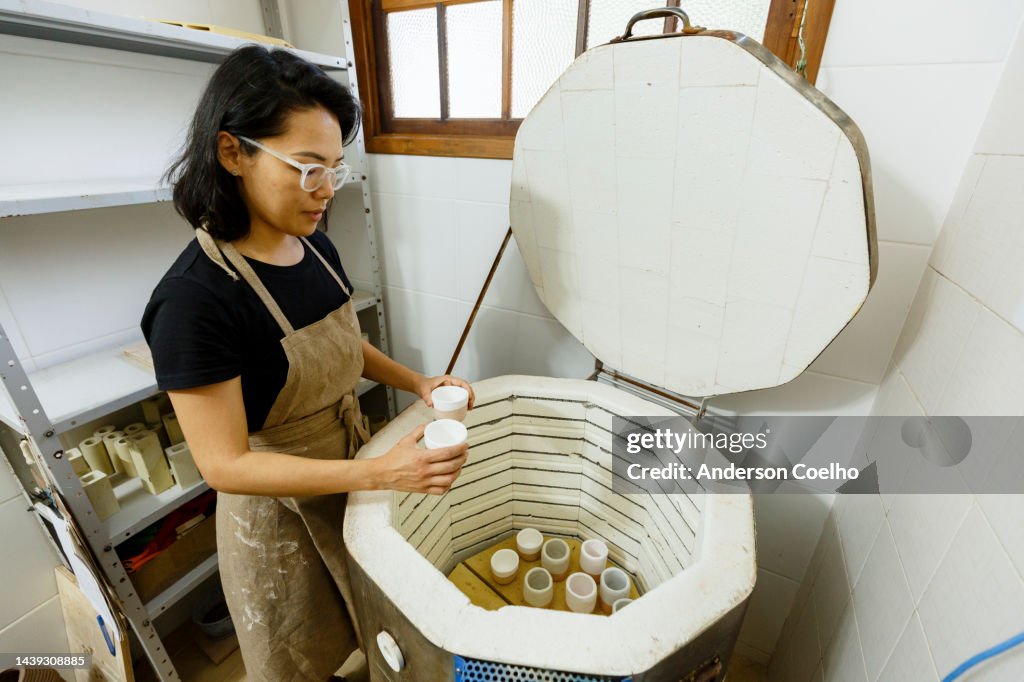 Ceramist drying clay pieces in an oven