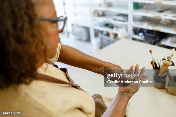 donna nera di mezza età che modella l'argilla - clay foto e immagini stock