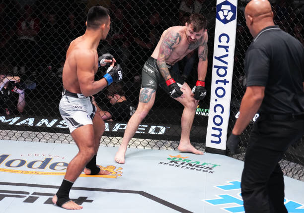 Darrick Minner reacts after suffering an apparent injury against Shayilan Nuerdanbieke of China in a featherweight fight during the UFC Fight Night...