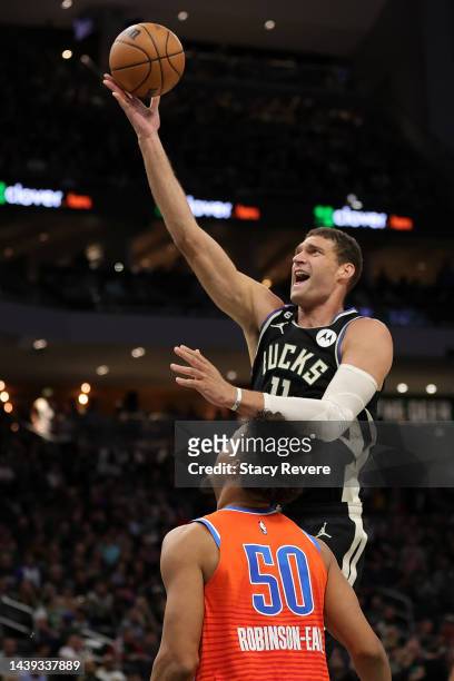 Brook Lopez of the Milwaukee Bucks shoots over Jeremiah Robinson-Earl of the Oklahoma City Thunder during the first half of a game at Fiserv Forum on...