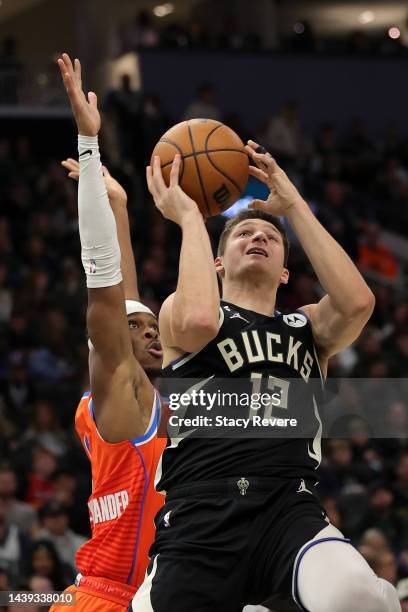 Grayson Allen of the Milwaukee Bucks is defended by Shai Gilgeous-Alexander of the Oklahoma City Thunder during the first half of a game at Fiserv...