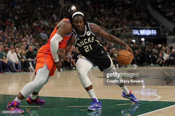 Jrue Holiday of the Milwaukee Bucks is defended by Luguentz Dort of the Oklahoma City Thunder during the first half of a game at Fiserv Forum on...