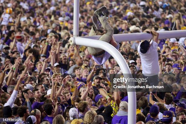 Fans climb the goal post after storming the field to celebrate their win against the Alabama Crimson Tide at Tiger Stadium on November 05, 2022 in...