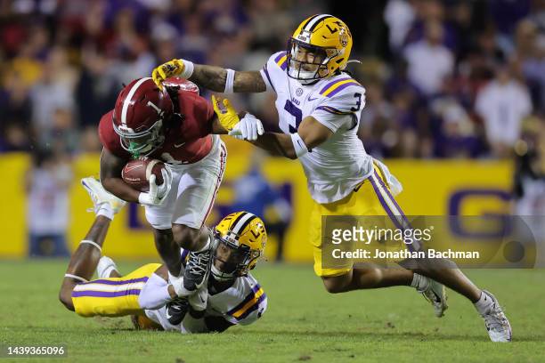 Jahmyr Gibbs of the Alabama Crimson Tide is tackled by Greg Brooks Jr. #3 and Jay Ward of the LSU Tigers during the first half at Tiger Stadium on...