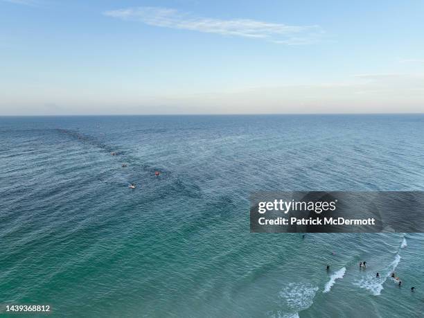 An aerial view of age group athletes competing in the swim course at IRONMAN Florida on November 05, 2022 in Panama City Beach, Florida.