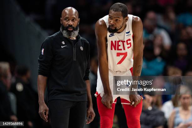 Interim head coach Jacque Vaughn of the Brooklyn Nets talks with Kevin Durant during their game at Spectrum Center on November 05, 2022 in Charlotte,...