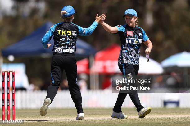 Jemma Barsby of the Strikers is high fived by Bridget Patterson after taking two wickets in her first over during the Women's Big Bash League match...