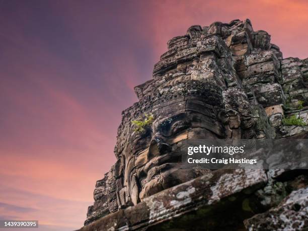 siem reap cambodia temple faces - ancient civilisation of the khmer city complex face sculpture with over grown jungle, trees and nature. top tourist attraction, travel, tourism and adventure concept. - siemreap tempelkomplex stock-fotos und bilder
