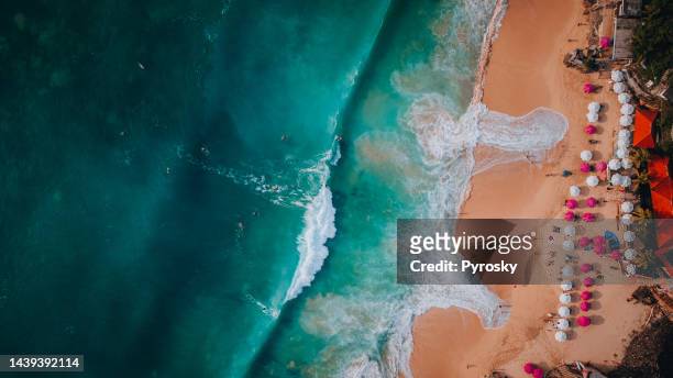 aerial view of beach waves splashing on the sandy beach - society of peace stock pictures, royalty-free photos & images