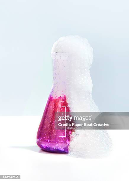 pink experimental flask bubbling excessively - chemical reaction stock pictures, royalty-free photos & images