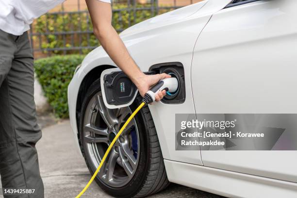 electric vehicle during the charging process - electric cars stockfoto's en -beelden