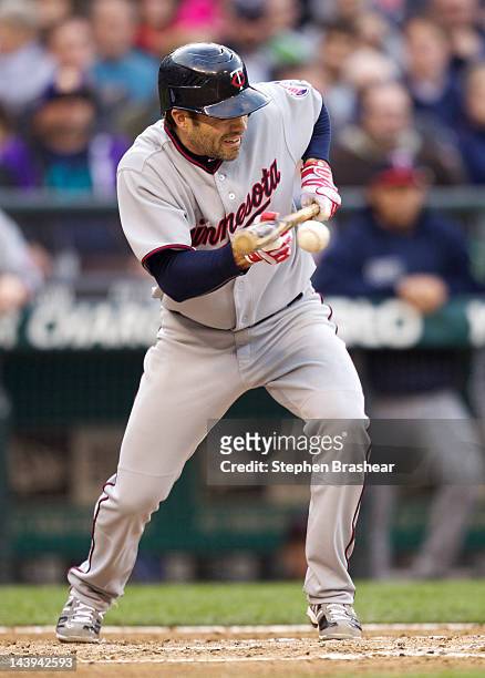 Jamey Carroll of the Minnesota Twins lays down a sacrifice bunt during a game against the Seattle Mariners at Safeco Field on May 5, 2012 in Seattle,...
