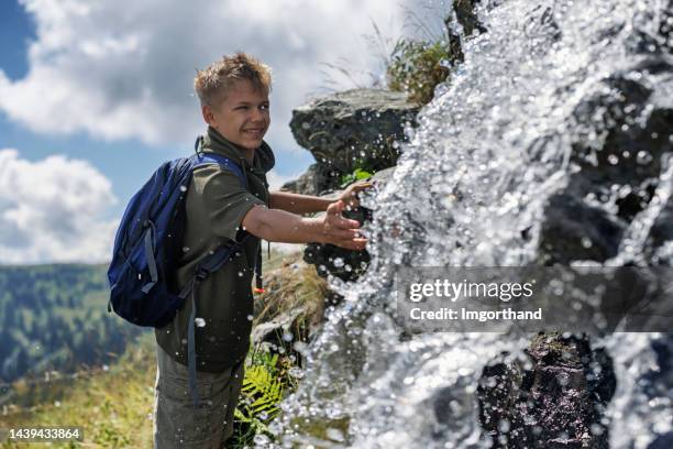 teenager wandert in den österreichischen bergen und erreicht einen wasserfall - gebirgsbach stock-fotos und bilder