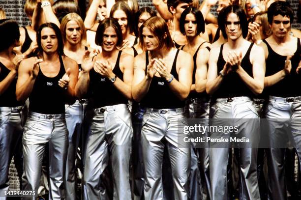 Models applaud on the runway at show finale.