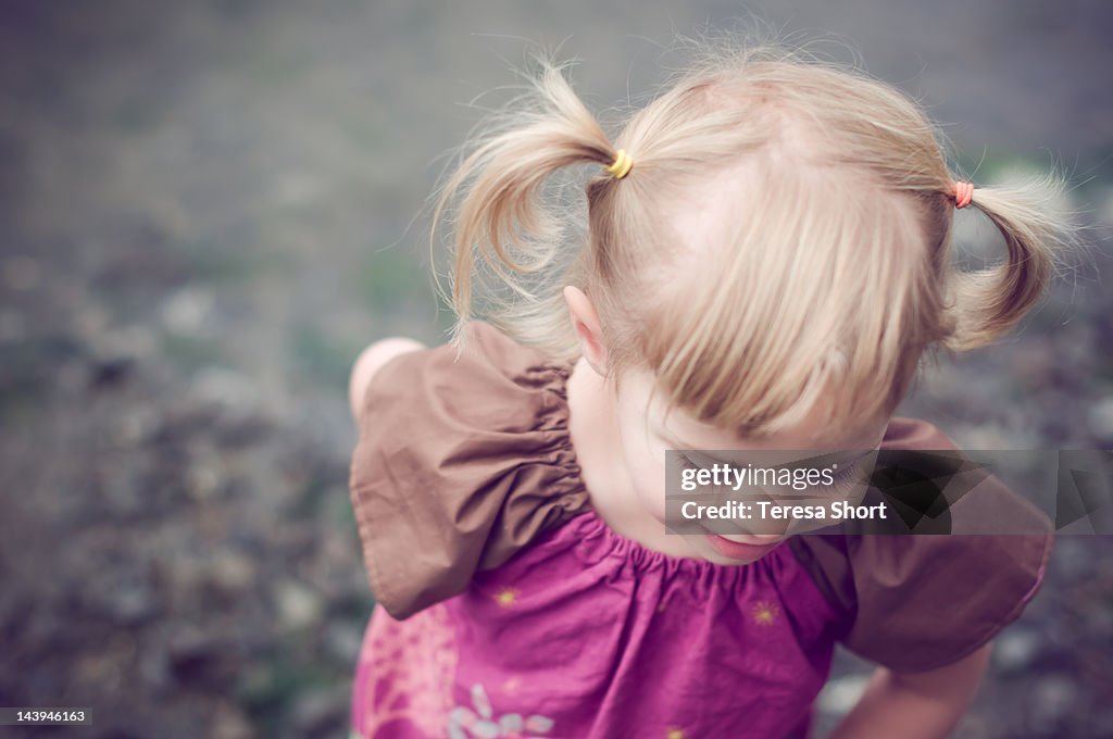 Girl with pigtails looking down