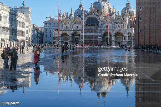 Tourists and locals walk in St. Mark's Square flooded by high tide on November 06, 2022 in Venice, Italy.