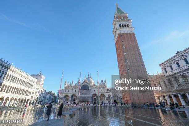 Tourists and locals walk through flooded St. Mark's Square on November 06, 2022 in Venice, Italy.