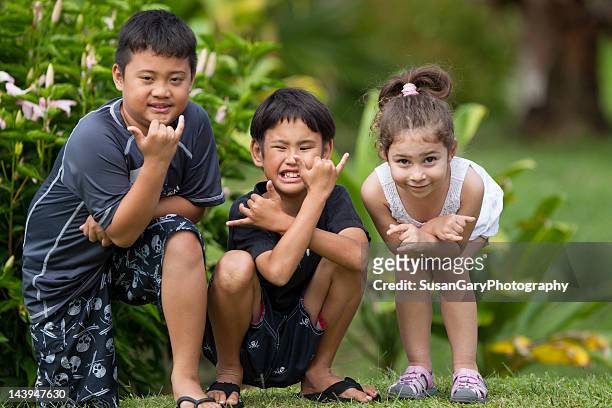 three children give hang loose hand sign - hilo stock pictures, royalty-free photos & images